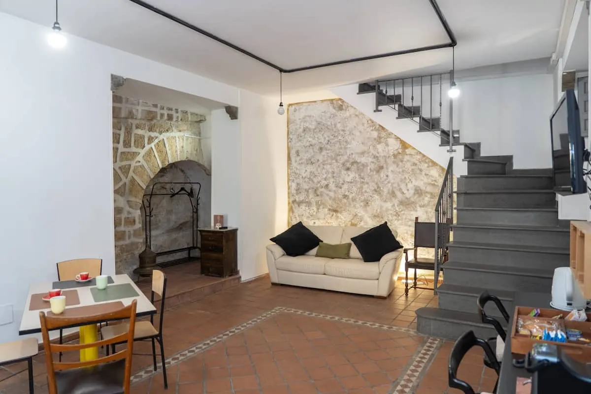 Il salotto con l'arco in pietra e la scala per il piano superiore